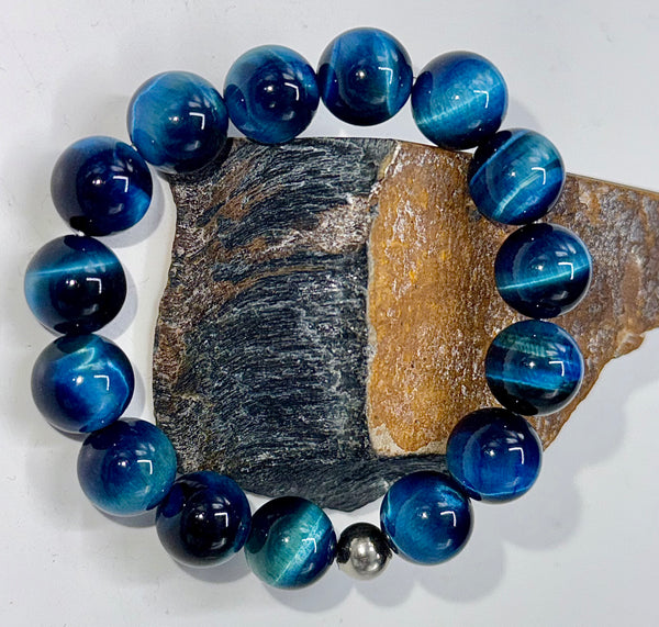 Blue Tiger Eye bracelet featuring dark and light stones from STICS and STONES, showcasing polished gemstone beads on an elastic band.