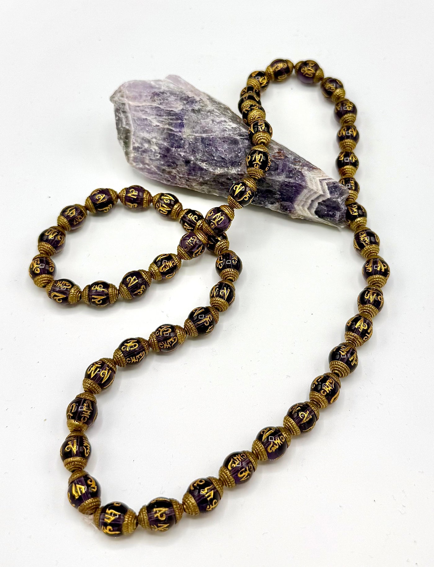 Amethyst necklace with carved pendant from STICS and STONES, showcasing a polished purple gemstone on a delicate chain.