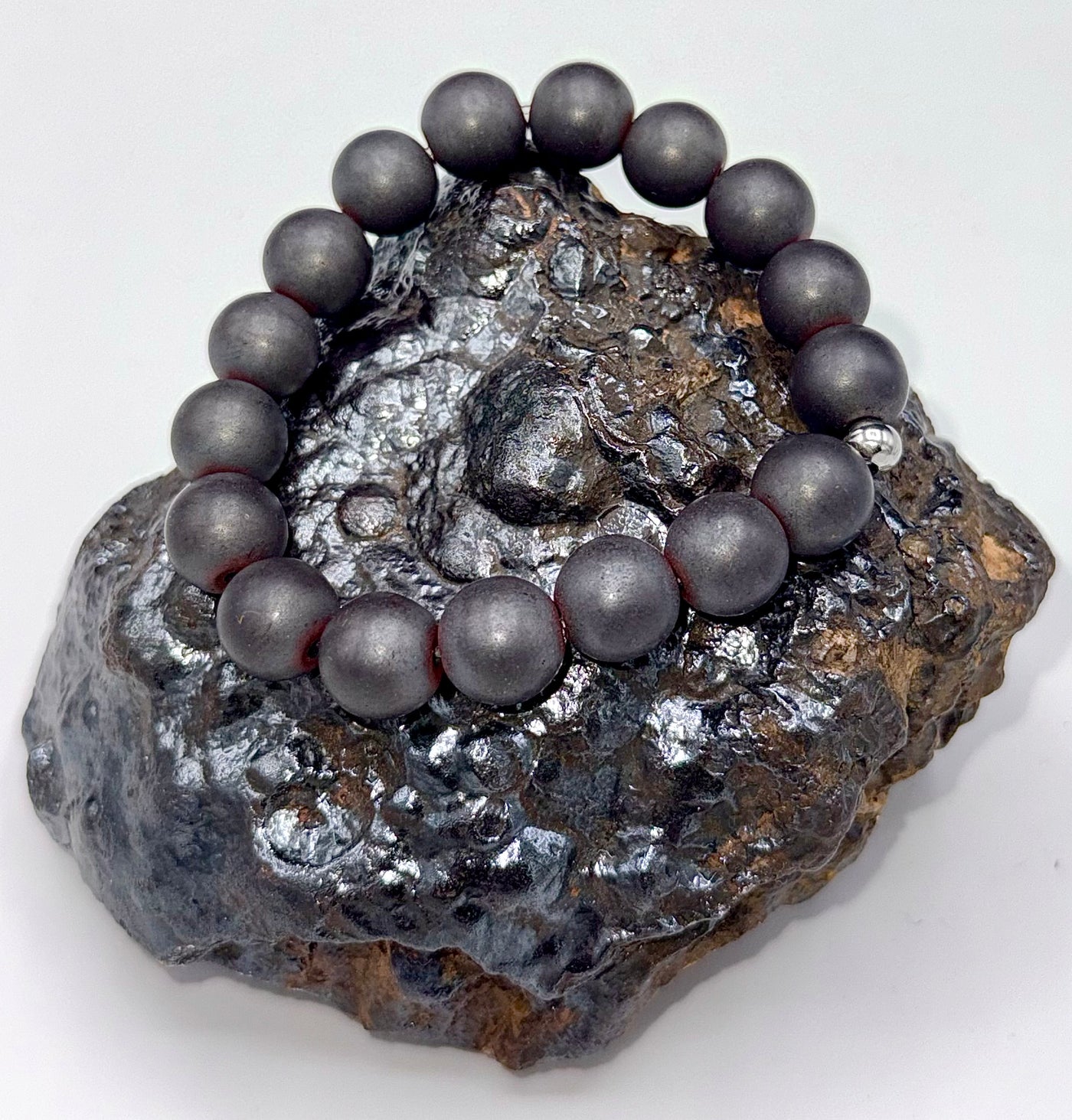 Matte hematite bracelet by STICS and STONES featuring smooth, dark gray beads on an elastic band.