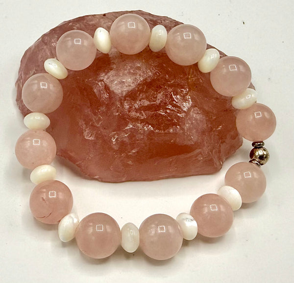Rose quartz bracelet with pearl spacers from STICS and STONES, featuring smooth pink stones and white pearl accents.