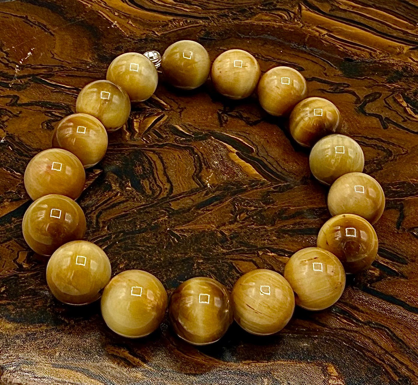 Golden Tiger Eye bracelet featuring polished beads from STICS and STONES, displayed on a neutral background.