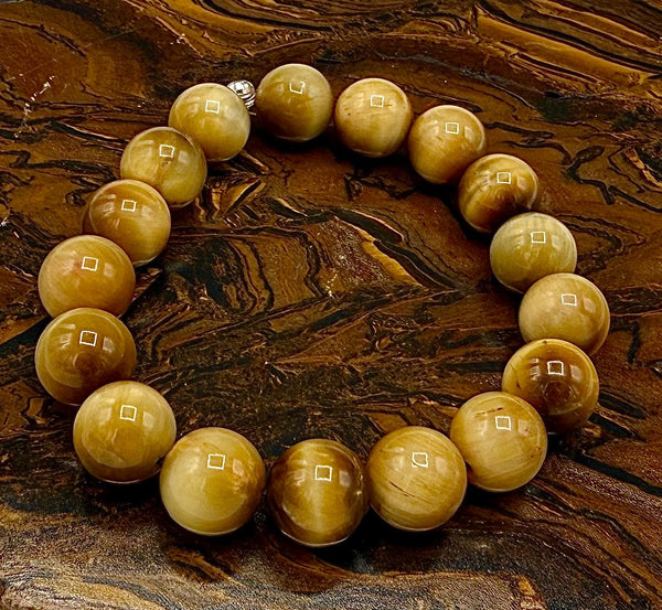 Golden Tiger Eye bracelet featuring polished beads from STICS and STONES, displayed on a neutral background.