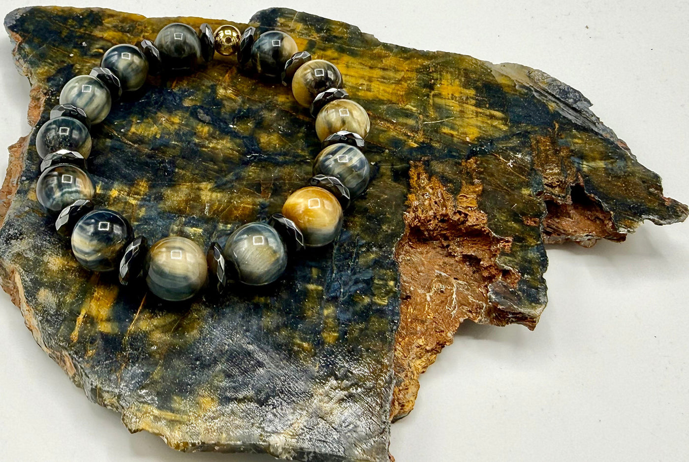 Black, gold, and grey tiger eye bracelet by STICS and STONES featuring polished tiger eye beads on an elastic band.