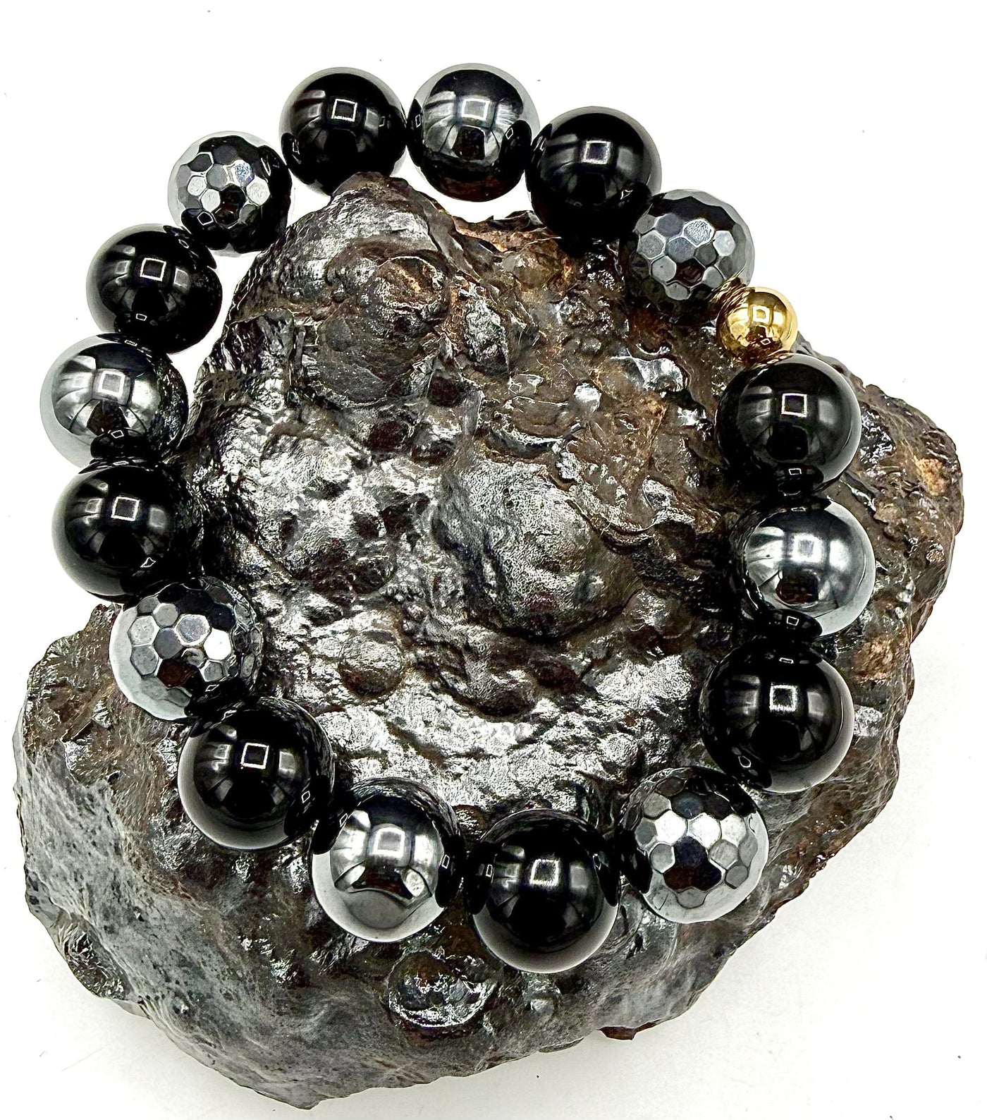Faceted black onyx and hematite bracelet featuring shiny black stones and metallic accents, crafted by STICS and STONES.