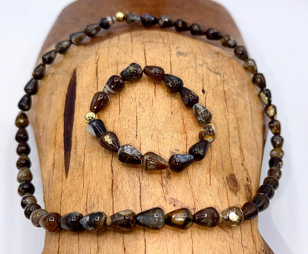 Brown agate jewelry set with necklace and bracelet from STICS and STONES, featuring polished stone beads on a display.