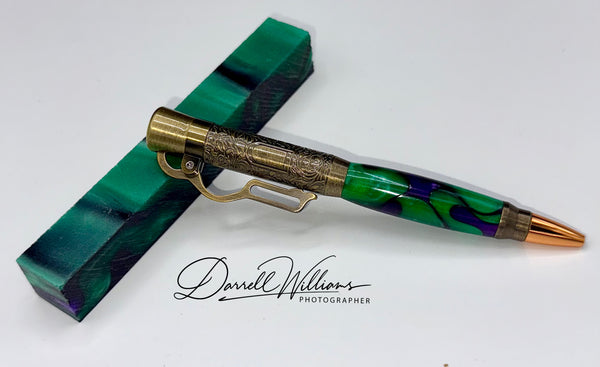 Hand-turned Royal Purple and Green rifle-shaped pen by STICS and STONES, featuring a polished wooden finish and detailed design.