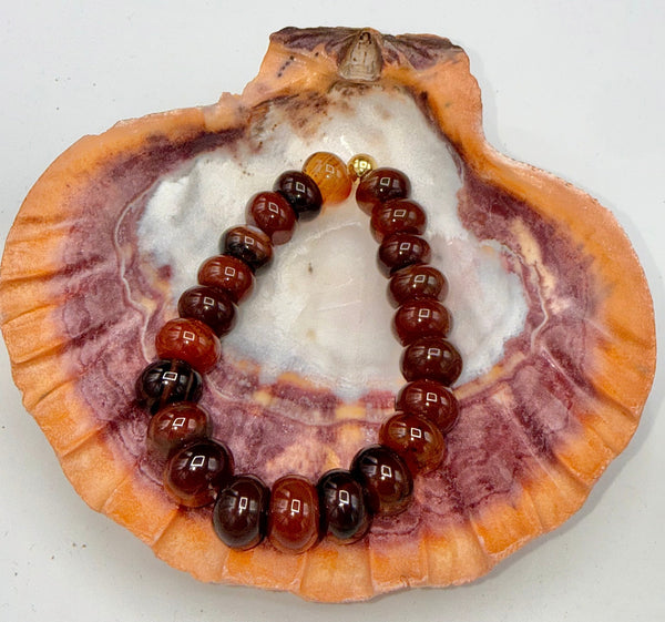 Carnelian bracelet featuring polished orange-red stones from STICS and STONES, displayed on a neutral background.