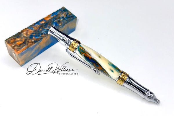 Hand-turned blue and gold acrylic and bone pen by STICS and STONES, featuring a sleek, artistic design for writing and display.