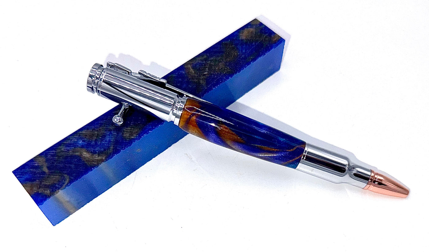 Hand-turned blue and gold acrylic bullet pen by STICS and STONES, featuring a sleek, polished design with metal accents.