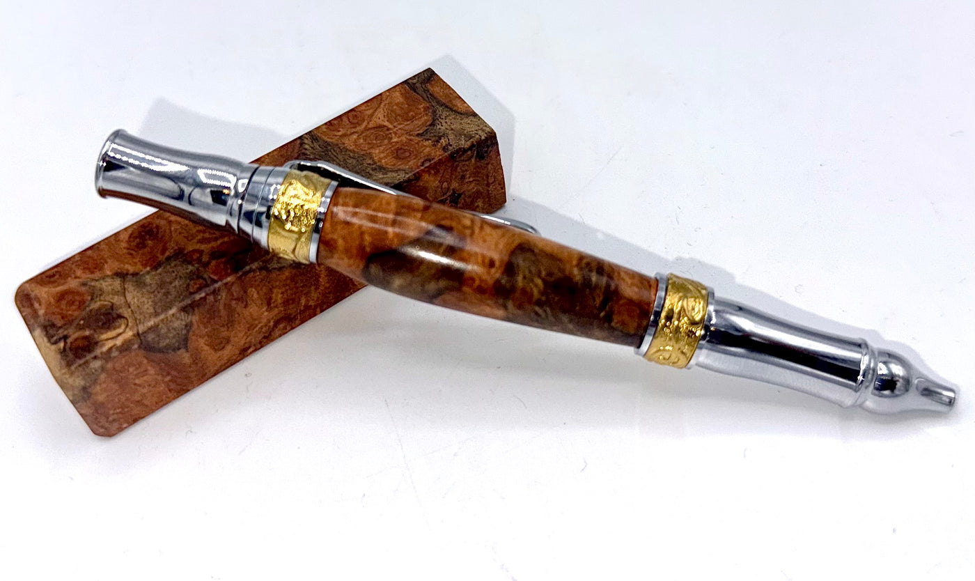 Hand-turned Gmelina burl wood pen by STICS and STONES showing a smooth, polished wooden pen with metal accents.