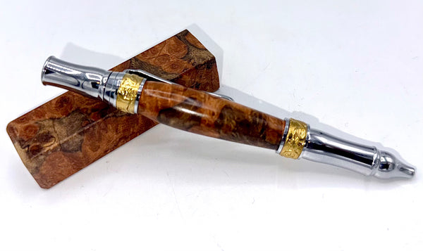 Hand-turned Gmelina burl wood pen by STICS and STONES showing a smooth, polished wooden pen with metal accents.