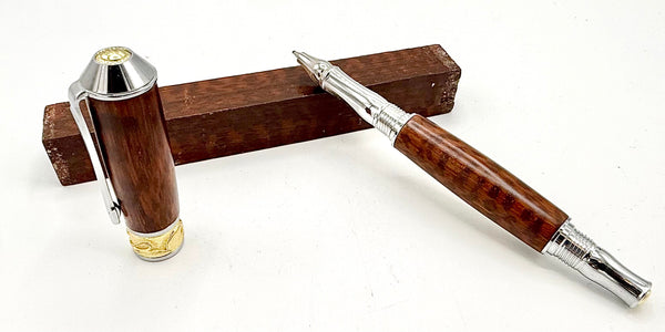 Hand-turned South American Snakewood pen by STICS and STONES, showcasing polished wood with a sleek metal clip and fine writing tip.
