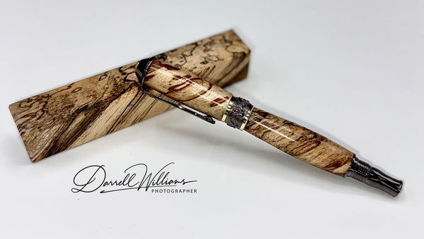 Hand-turned spalted wood pen by STICS and STONES, showcasing intricate grain patterns and a smooth polished finish.