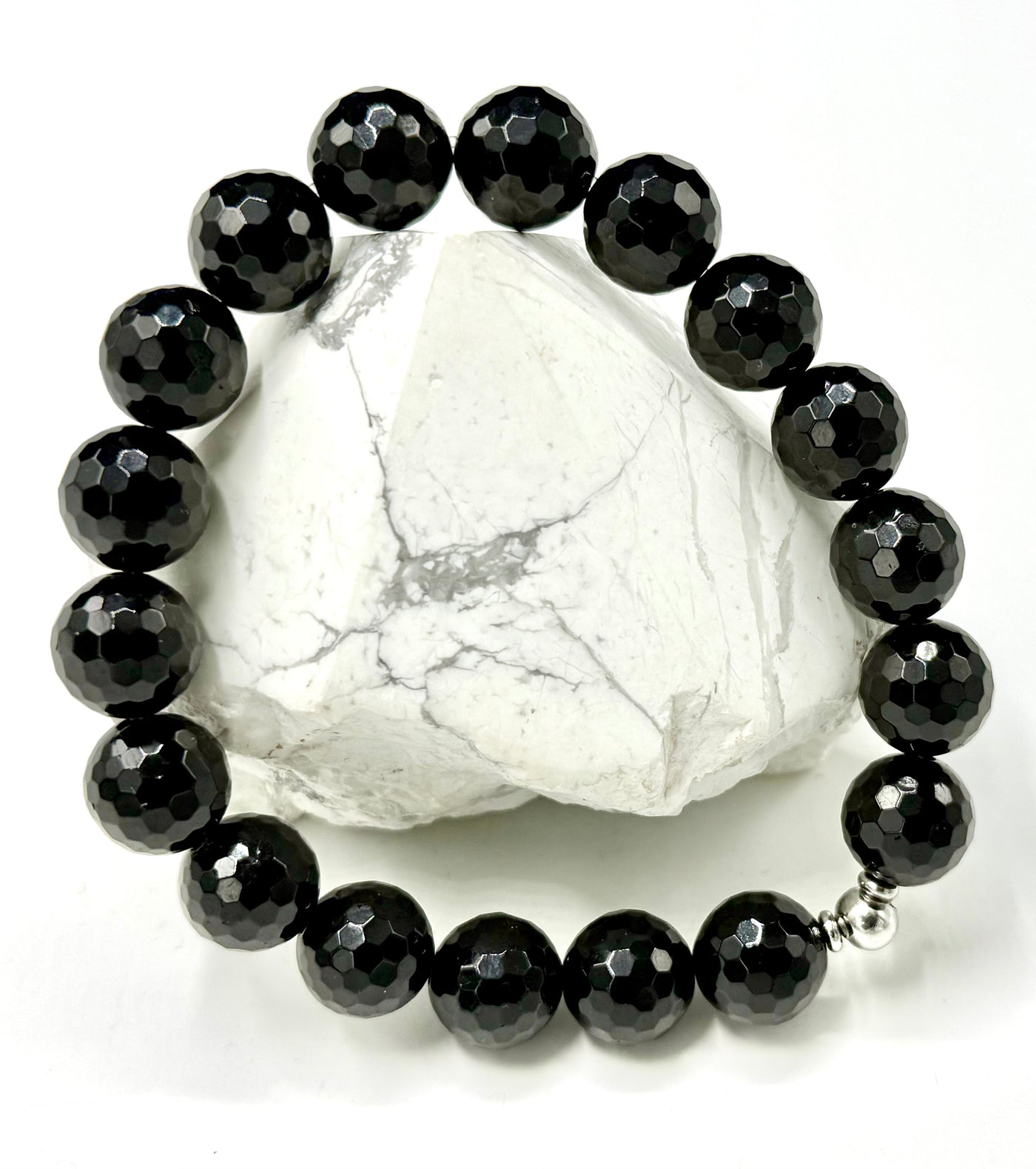 Faceted black onyx bracelet from STICS and STONES with smooth, polished beads on a stretch cord.