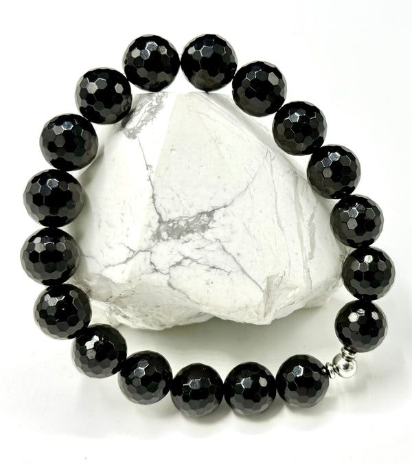 Faceted black onyx bracelet from STICS and STONES with smooth, polished beads on a stretch cord.