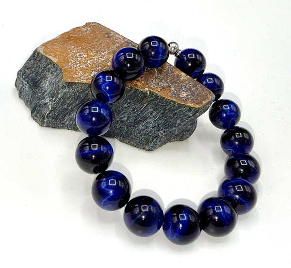 Dyed blue tiger eye bracelet from STICS and STONES featuring polished oval beads strung together on elastic.