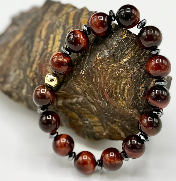 Red Tiger Eye bracelet featuring polished beads from STICS and STONES, displayed on a neutral background.
