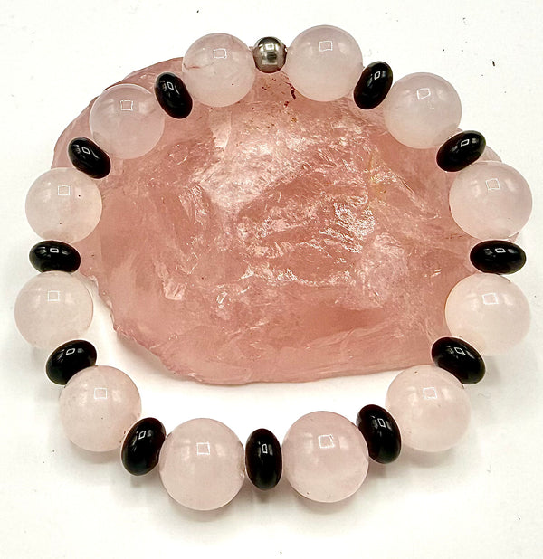 Rose quartz and onyx spacer bracelet from STICS and STONES, featuring pink gemstones and black onyx beads with elastic band.