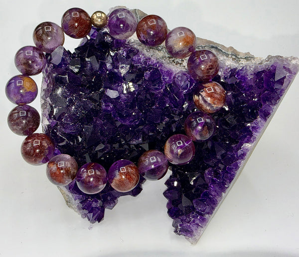 Super Seven bracelet by STICS and STONES featuring polished gemstone beads and a silver clasp on a neutral background.