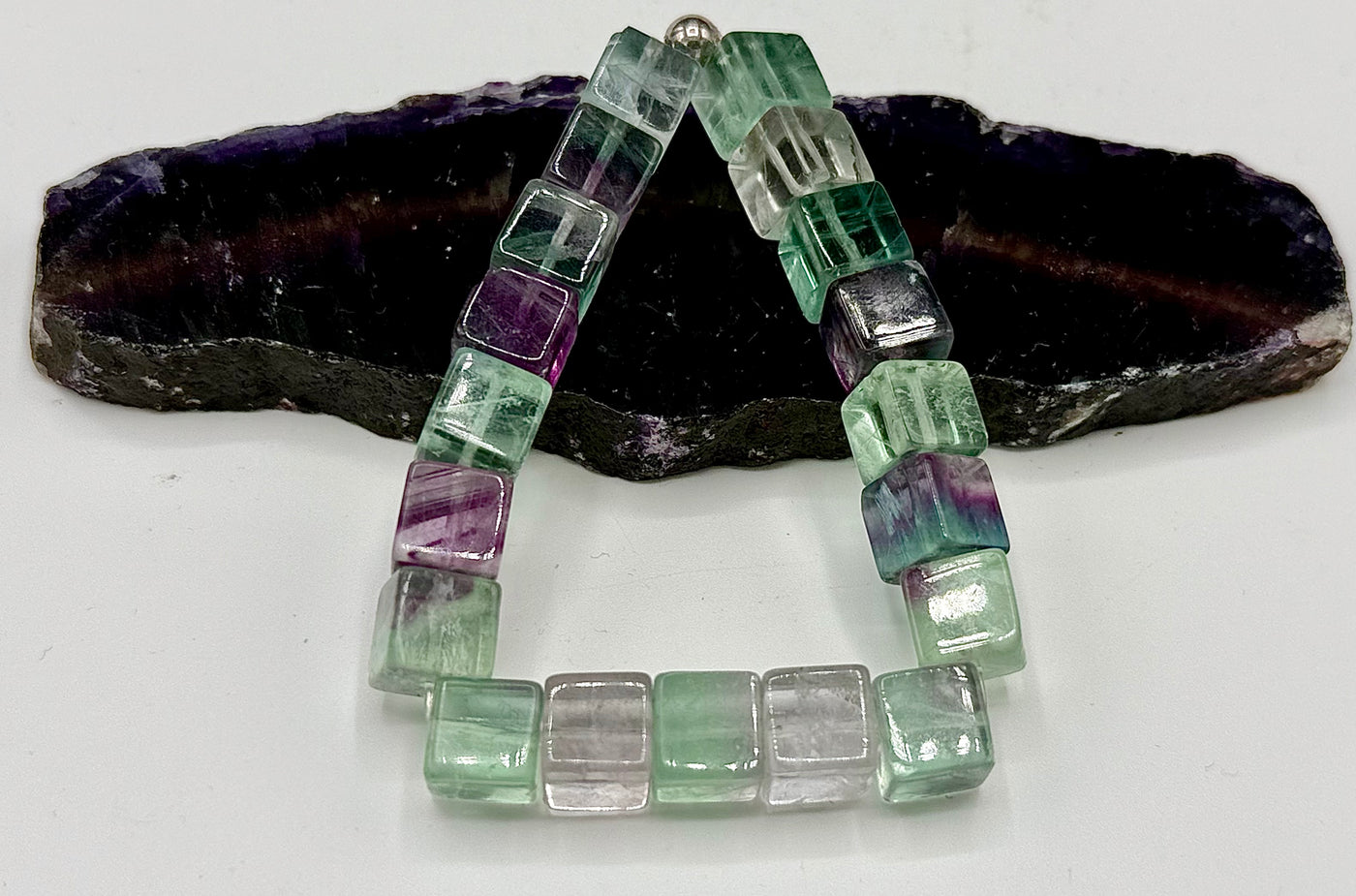 Square fluorite bracelet from STICS and STONES featuring vibrant green and purple stones on a delicate chain.