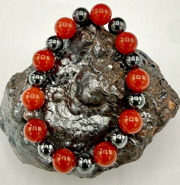 Carnelian and hematite bracelet featuring polished beads, designed by STICS and STONES, displayed on a neutral background.