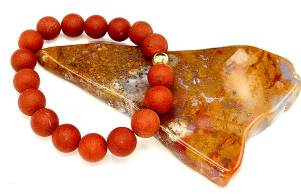 Red matte Jasper bracelet by STICS and STONES featuring smooth, rounded stone beads on an elastic band.