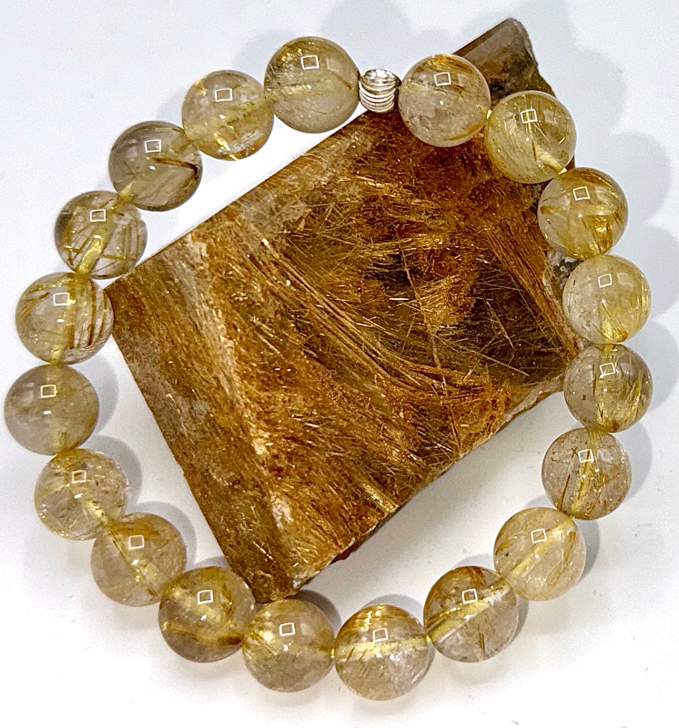 Rutilated Quartz bracelet by STICS and STONES featuring polished, golden needle-like inclusions on a sleek jewelry bracelet.