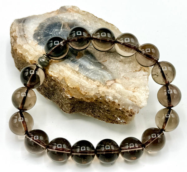 Smokey Quartz bracelet featuring polished beads from STICS and STONES, displayed on a neutral background.