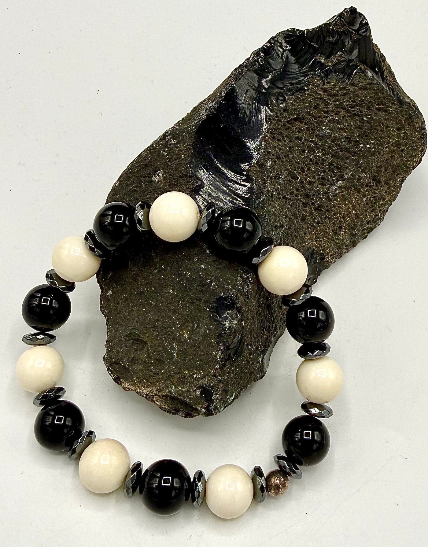 Onyx and bone bracelet by STICS and STONES featuring black onyx beads and white bone accents on a stretchy cord.