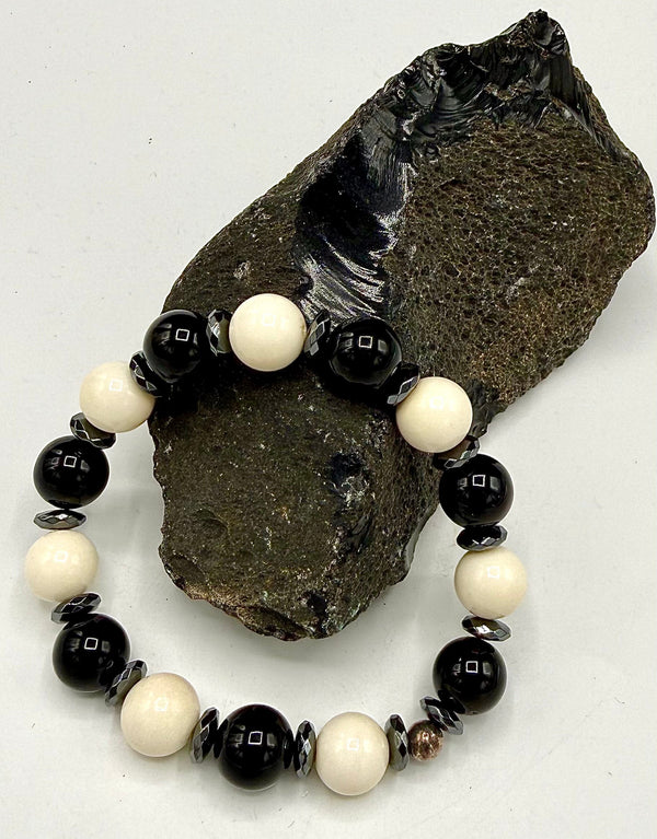 Onyx and bone bracelet by STICS and STONES featuring black onyx beads and white bone accents on a stretchy cord.