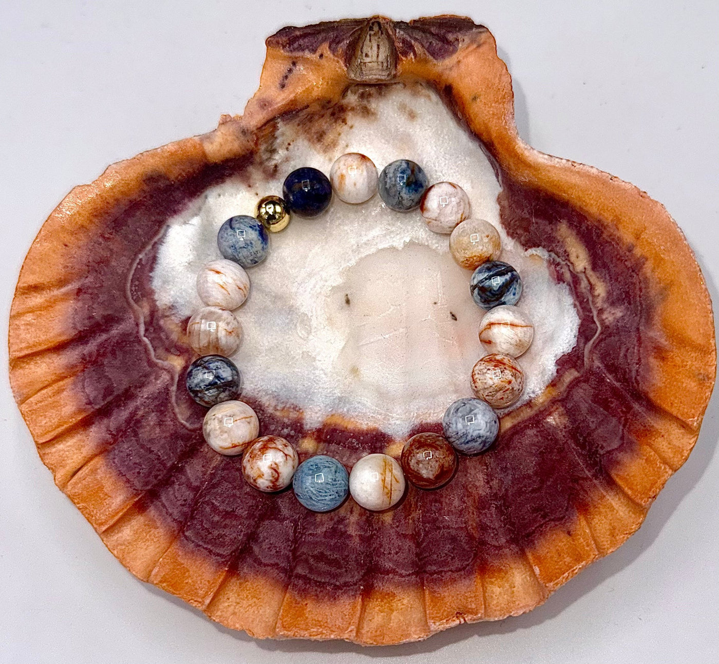 Close-up of Laguna Agate bracelet by STICS and STONES, showing polished agate beads on a string with intricate banding.