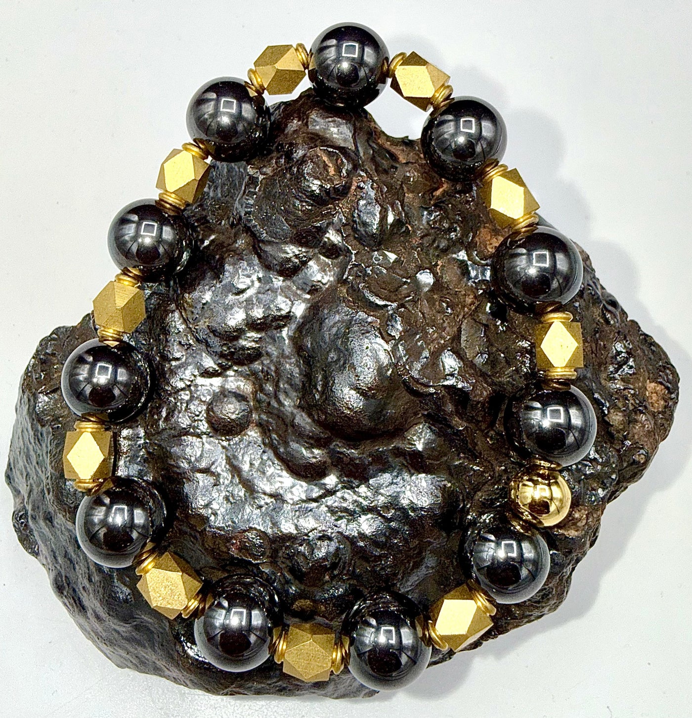 Hematite and brass bracelet with polished beads, featuring a stylish design by STICS and STONES.