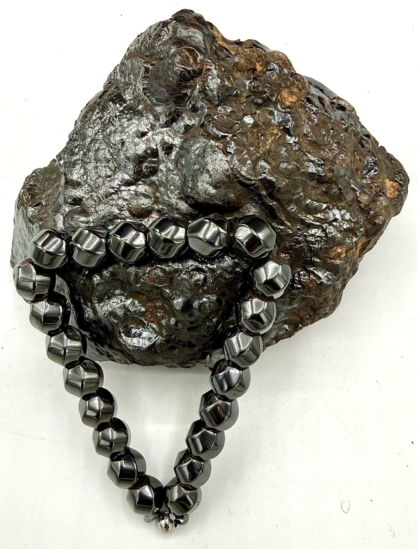 Magnetic hematite bracelet by STICS and STONES featuring smooth, rounded black hematite beads on an elastic band.