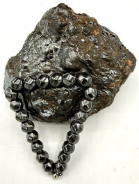 Magnetic hematite bracelet by STICS and STONES featuring smooth, rounded black hematite beads on an elastic band.