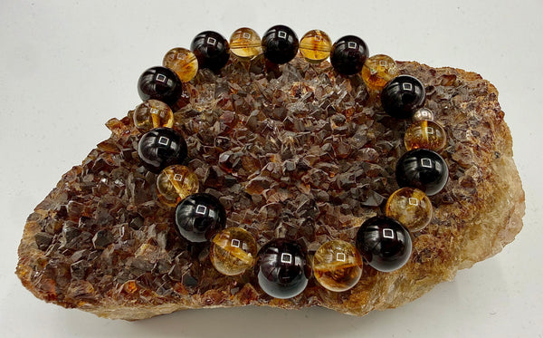 Garnet and citrine bracelet featuring polished gemstone beads from STICS and STONES, displayed on a neutral background.