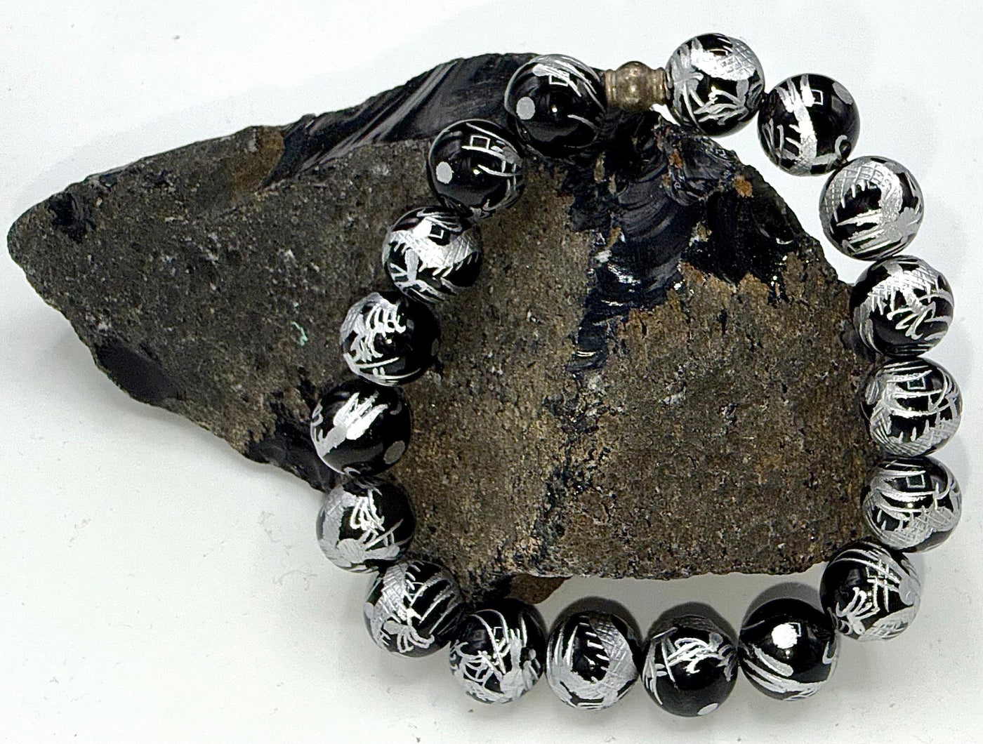 Black Onyx bracelet with gold writing by STICS and STONES, featuring polished black onyx beads and elegant gold accents.