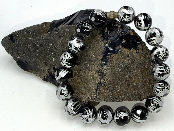 Black Onyx bracelet with gold writing by STICS and STONES, featuring polished black onyx beads and elegant gold accents.