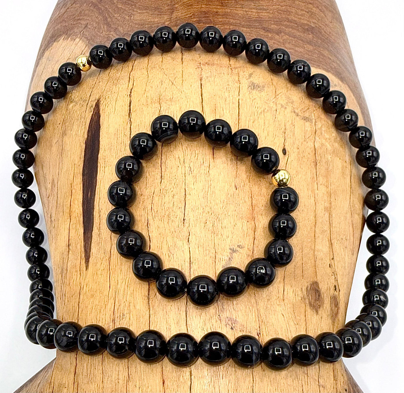 Black Onyx jewelry set including necklace and bracelet from STICS and STONES, featuring polished black onyx stones and silver accents.