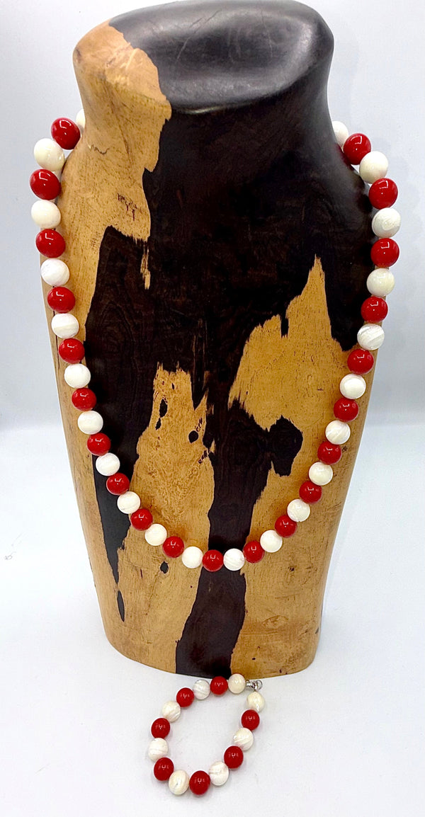 Red and white jewelry set featuring pearl bracelet and necklace by STICS and STONES, displayed on a neutral background.