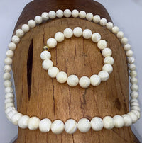 Pearl jewelry set featuring a necklace and bracelet with white pearls from STICS and STONES on a white background.