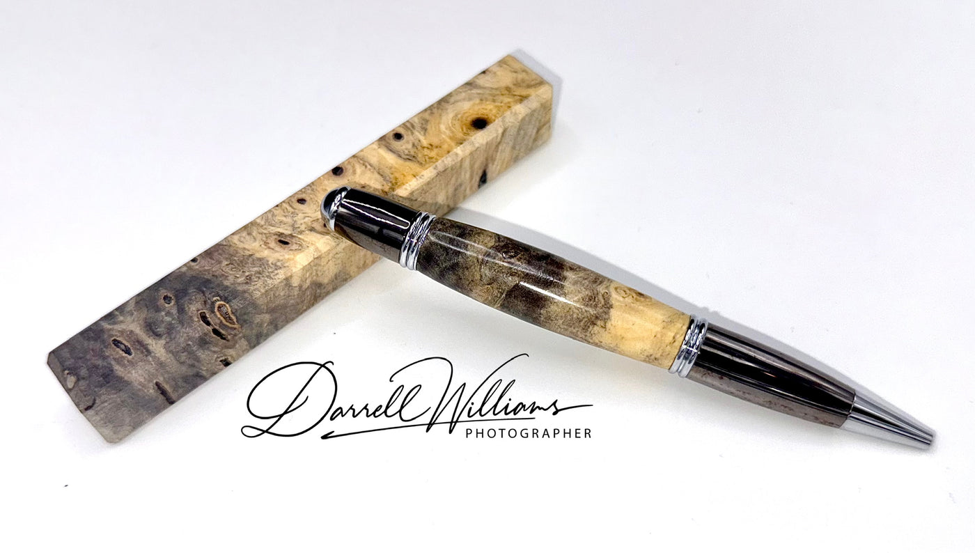 Hand-turned Buckeye Burl pen by STICS and STONES, showcasing polished wood with a sleek pen tip and elegant design.
