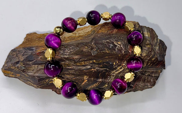 Purple tiger eye gemstone bracelet with brass accents, featuring dark and light tones, styled on a wrist for natural beauty.