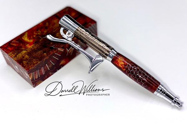 Hand-turned burgundy acrylic firefighter axe pen by STICS and STONES, featuring a detailed axe-shaped design with a metal clip.