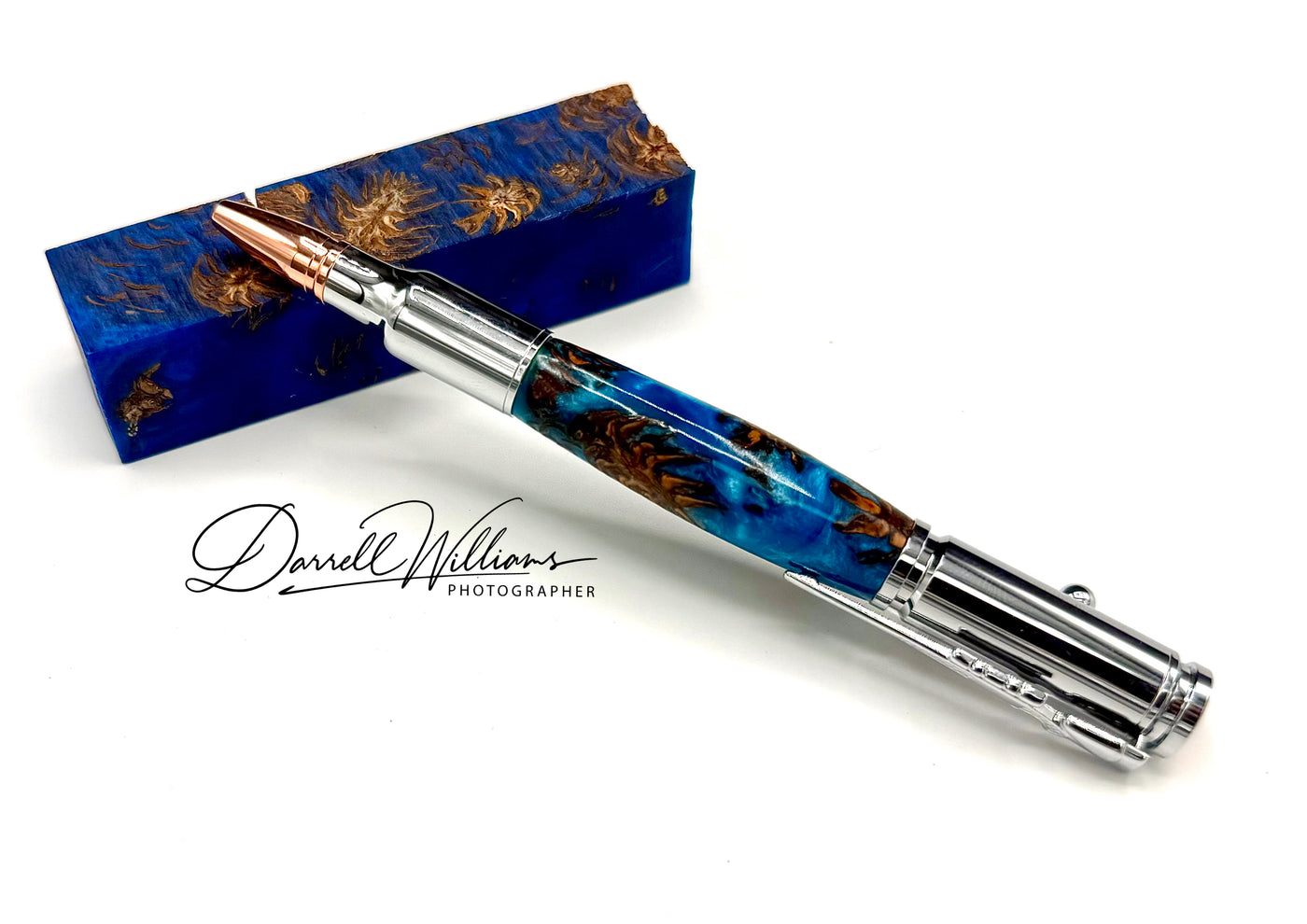 Hand-turned blue acrylic and wood cone bullet pen by STICS and STONES, featuring a sleek, polished design and intricate craftsmanship.