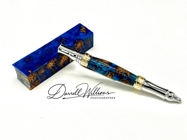 Hand-turned blue acrylic and hardwood pen by STICS and STONES, showcasing a sleek, polished writing instrument with a metal clip.