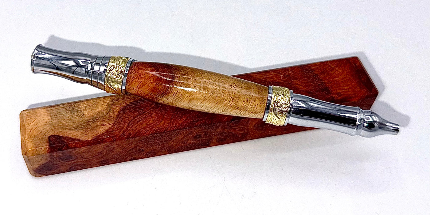 Hand-turned Amboyna Burl pen by STICS and STONES, showcasing polished wood with elegant craftsmanship and fine writing tip.